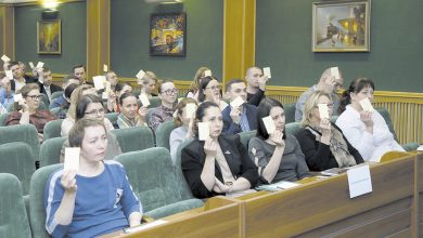 Участники профсоюзной конференции голосуют карточками