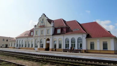 Здание вокзала с красной черепичной крышей у путей