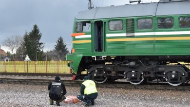 Двое сотрудников у свёртка на путях рядом с тепловозом