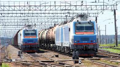 Два электровоза в бело-синей окраске с грузовыми составами на станции