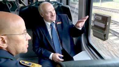 Двое мужчин, один в форме железнодорожника, в салоне поезда, электросчётчик