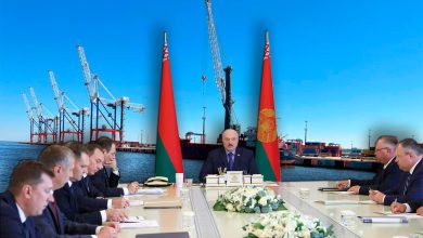 Совещание за столом на фоне флагов Беларуси и портовых кранов