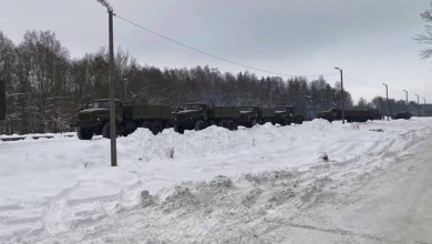 Колонна военных грузовиков у станции зимой