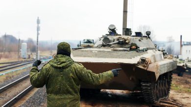 Военнослужащий подаёт сигнал при погрузке боевой машины пехоты на платформу