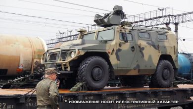 Бронеавтомобиль «Тигр» на платформе и военнослужащий у состава, надпись «Изображение носит иллюстративный характер»