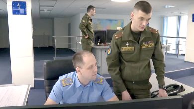 Диспетчер в форме железнодорожника и военнослужащий у пульта, рядом второй военнослужащий