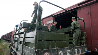 Военнослужащие перегружают ящики из крытого вагона в армейский грузовик