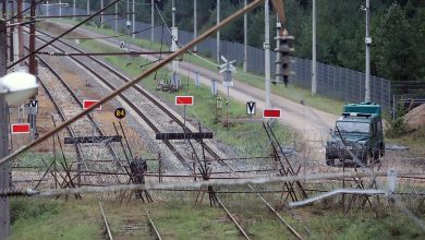 Железнодорожные пути у границы, перекрытые заграждениями, вдали бронированный автомобиль
