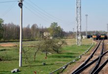 Станционные пути и опоры контактной сети, вдали тепловоз с составом