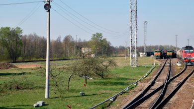 Станционные пути и опоры контактной сети, вдали тепловоз с составом
